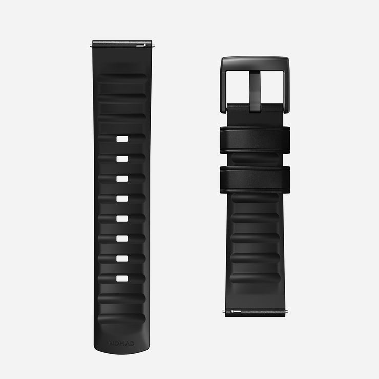 Two Nomad Active Band Pro - 22mm Quick Release straps in Black Horween leather with black hardware are shown side by side on a white background, one flat displaying sizing holes, the other folded to reveal the stainless steel buckle.