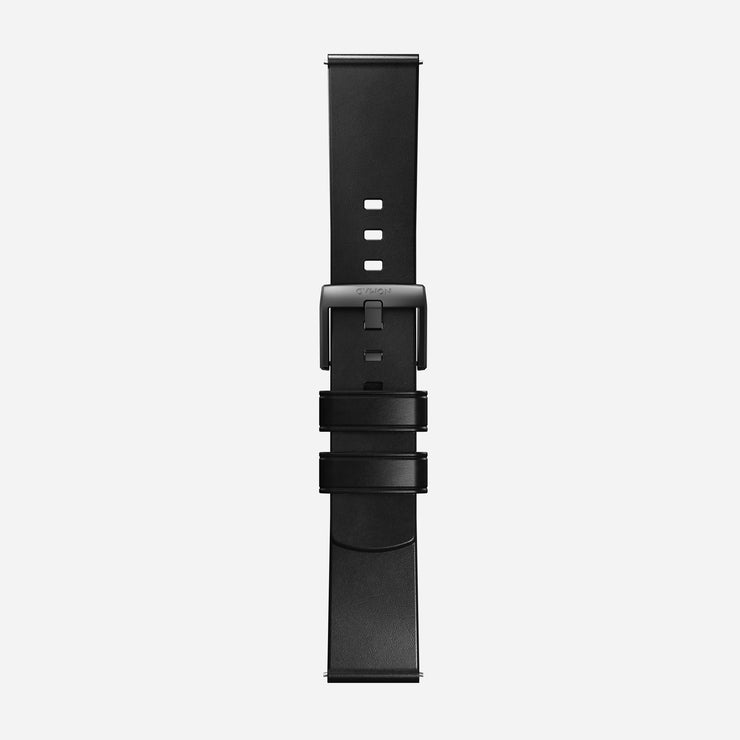 The Nomad Active Band Pro - 22mm Quick Release in Black Horween leather with black hardware is displayed vertically on a white background, showing its stainless steel buckle, matte finish, multiple adjustment holes, and dual loops.