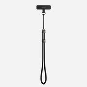 The Nomad Wrist Strap - Kevlar | Carbide is a black adjustable wrist lanyard with Kevlar reinforcement and a small rectangular attachment, designed for securing portable devices.