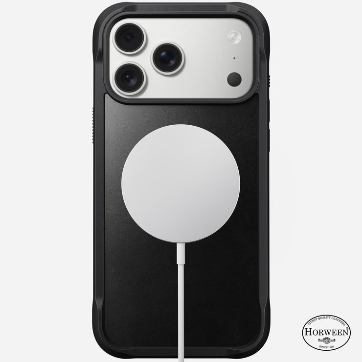The Nomad Rugged Leather Case for iPhone 17 Pro Max in black Horween leather features a MagSafe-compatible design for easy wireless charging, with the logo at the bottom right and shown here with a silver phone and white MagSafe charger.