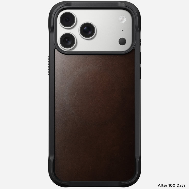 A Nomad Rugged Leather Case for iPhone 17 Pro Max in Rustic Brown Horween leather is shown upright, featuring a triple camera and black frame. "After 100 Days" appears in the bottom right corner.