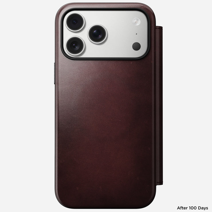 An iPhone 17 Pro Max in a Nomad Modern Leather Folio case, crafted from Burgundy Horween leather, is shown against a white background. "After 100 Days" appears in the lower right corner.