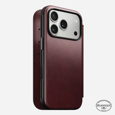 The Nomad Modern Leather Folio for iPhone 17 Pro in Burgundy Horween leather is shown upright, displaying three rear cameras and an open, book-style MagSafe compatible case with the Horween Leather Co. logo at the bottom right.