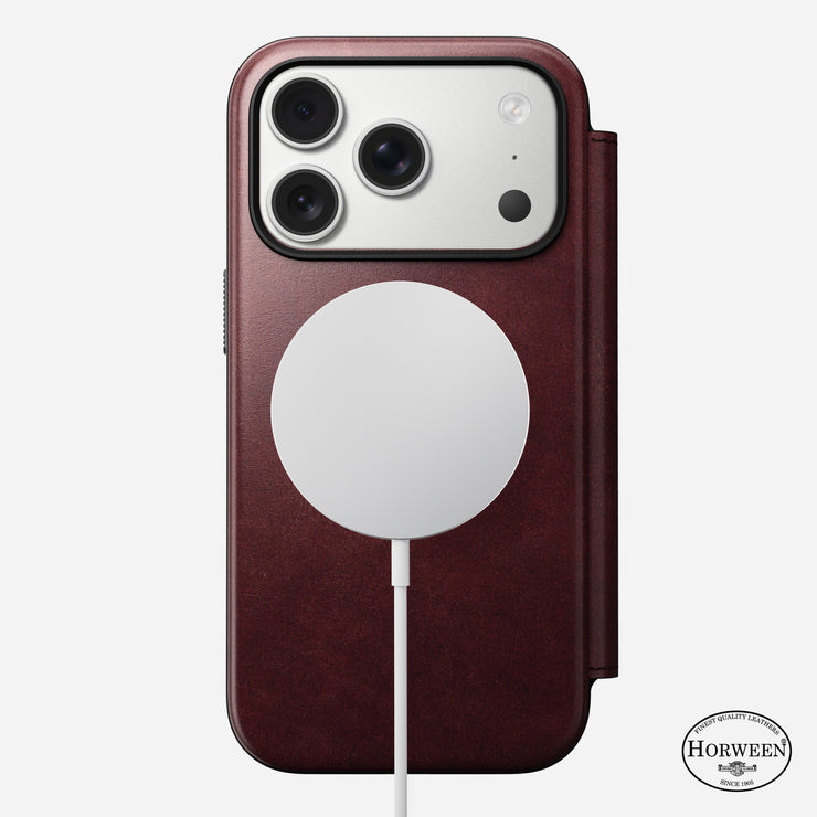 An iPhone 17 Pro in a Nomad Modern Leather Folio (Burgundy, Horween) with 8ft drop protection and MagSafe charger attached; the Horween logo appears at the bottom right.