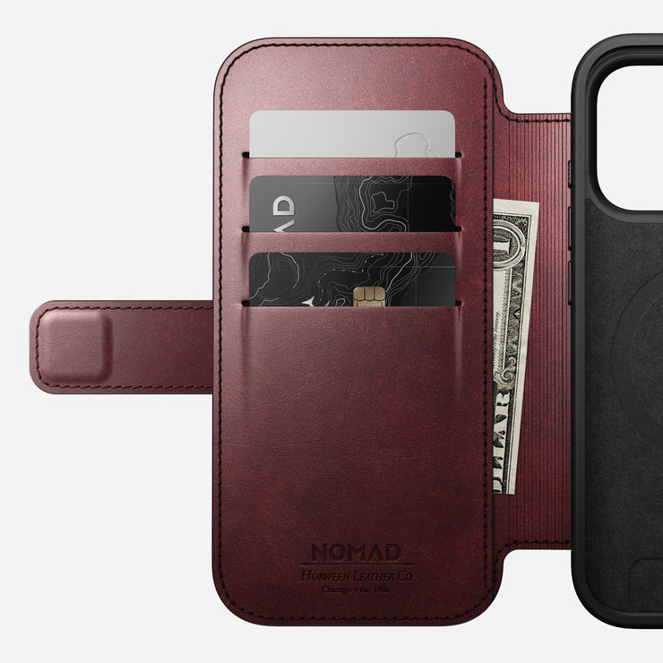 The Modern Leather Folio for iPhone 17 Pro by Nomad is crafted from burgundy Horween leather, features three card slots, holds two cards and cash, has "NOMAD Horween Leather Co. Chicago, IL 1905" embossed inside, and is MagSafe compatible.