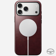 An iPhone 17 Pro Max in a Nomad Modern Leather Case (Burgundy, Horween), featuring 8ft drop protection and the Horween logo at the bottom right, with a white circular MagSafe charger attached to the back.