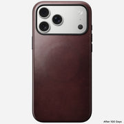 A Nomad Modern Leather Case in Burgundy Horween on an iPhone 17 Pro Max, photographed from the back after 100 days, shows circular wear marks.