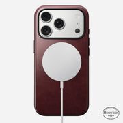A Nomad Modern Leather Case for iPhone 17 Pro in Burgundy Horween leather features a circular white MagSafe charger on the back, with the Horween leather logo at the bottom right, highlighting elegance and MagSafe compatibility.