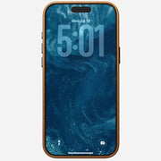 An iPhone 17 Pro Max in a brown Nomad Traditional Leather Case displays a lock screen with the time 5:01, date Wed, Jul 18, and blue abstract background. Flashlight and camera icons are visible at the bottom. Case is MagSafe compatible.