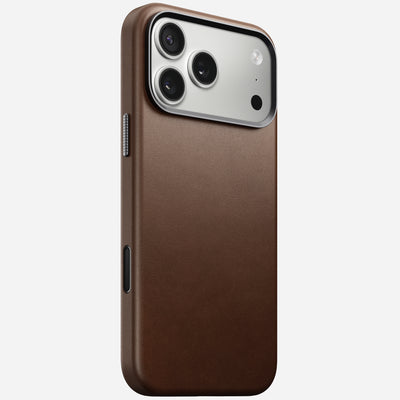 The Nomad Traditional Leather Case in brown, shown on the iPhone 17 Pro Max with a silver three-camera module, features sleek full-grain leather and is displayed from the back against a plain white background.