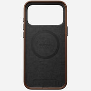 The Nomad Traditional Leather Case for iPhone 17 Pro Max in brown features full-grain leather, a large rectangular camera cutout, side button covers, and NOMAD centered within a circular design on the back.