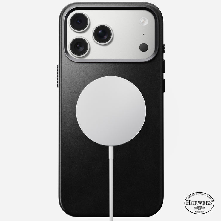 The Nomad Traditional Leather Case in black Horween leather is shown on an iPhone 17 Pro Max with a MagSafe charger attached. The Horween logo at the bottom right highlights its premium, MagSafe-compatible design.