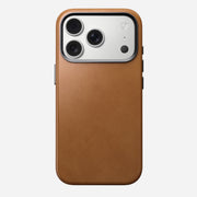 The Nomad Traditional Leather Case in English Tan for iPhone 17 Pro is shown from the back, featuring three rear cameras and a flash. The MagSafe compatible brown leather case appears against a plain white background.
