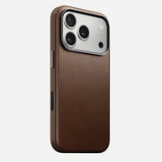 The Nomad Traditional Leather Case for iPhone 17 Pro in brown, featuring MagSafe compatibility, large camera lenses, and side buttons, is shown against a plain white background.