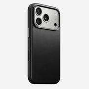 The Nomad Traditional Leather Case for iPhone 17 Pro in black features sustainably sourced full-grain leather with a smooth finish, shown on a triple-camera phone with flash against a white background.