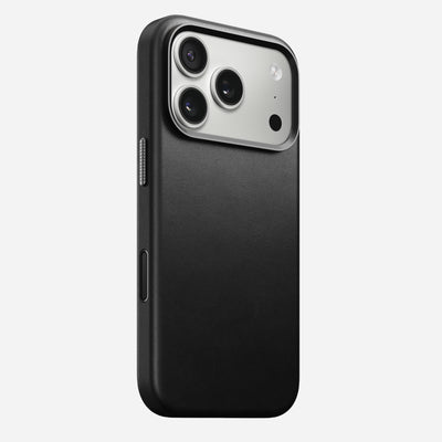 The Nomad Traditional Leather Case for iPhone 17 Pro in black features sustainably sourced full-grain leather with a smooth finish, shown on a triple-camera phone with flash against a white background.