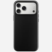 The Nomad Modern Case in Vulcan Black for iPhone 17 Pro Max is shown from the back, highlighting the silver triple-lens camera and flash. It features a durable TPU bumper and supports MagSafe charging, displayed on a light gray background.