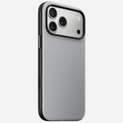 The Nomad Modern Case for iPhone 17 Pro Max in Lunar Gray showcases a sleek, minimalist silver and black look, with MagSafe compatibility, three rear cameras, and a flash in the top left corner—displayed at an angle on a white background.