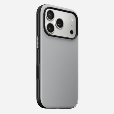 The Nomad Modern Case for iPhone 17 Pro in Lunar Gray is shown angled to highlight its sleek silver back, black edges, triple camera cutout with flash, and durable TPU bumper.