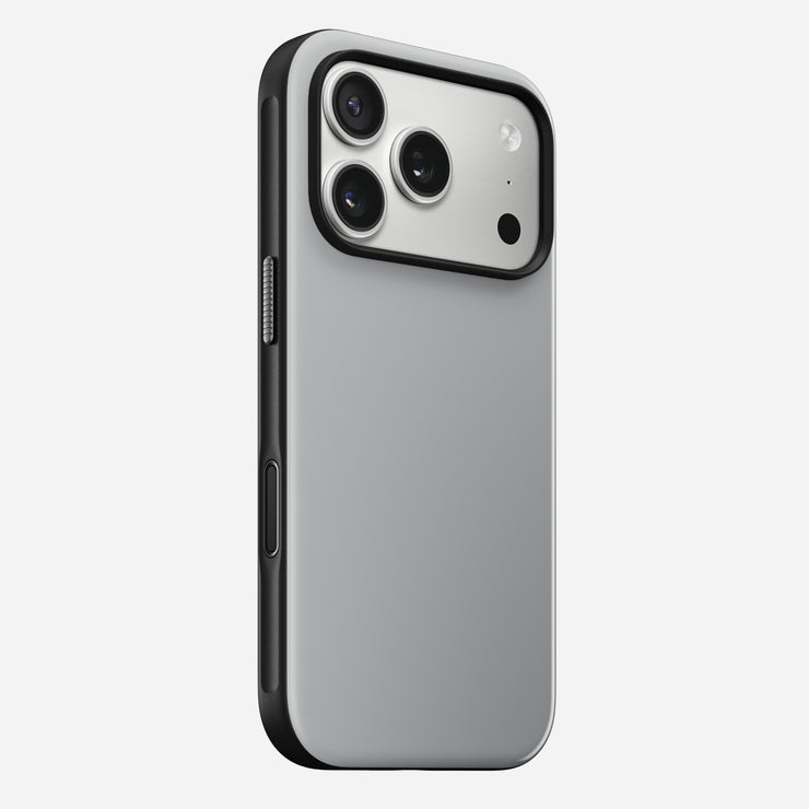 The Nomad Modern Case for iPhone 17 Pro in Lunar Gray is shown angled to highlight its sleek silver back, black edges, triple camera cutout with flash, and durable TPU bumper.