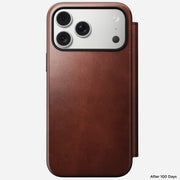 The Nomad Modern Leather Folio for iPhone 17 Pro Max in Olde Dublin Horween leather covers a triple-lens phone, showing a smooth patina and "After 100 Days" at the bottom right. MagSafe compatible for seamless wireless charging.