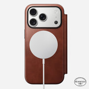 The Nomad Modern Leather Folio for iPhone 17 Pro in Olde Dublin Horween leather is shown from the back with a white MagSafe-compatible charger attached and the Horween logo visible in the bottom right corner.