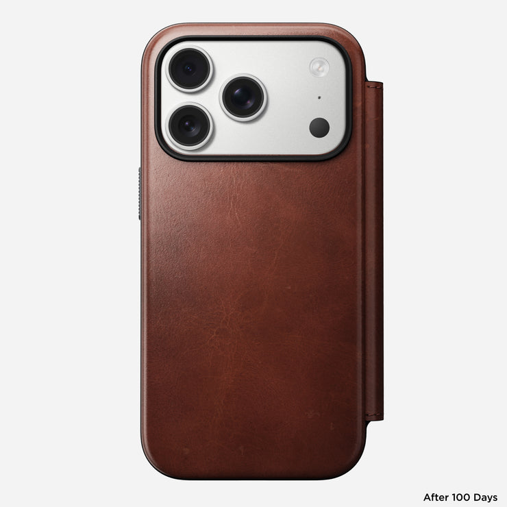 A Nomad Modern Leather Folio for iPhone 17 Pro in Olde Dublin Horween leather is shown from the back, focusing on the camera. The smooth, worn texture stands out. "After 100 Days" appears in the lower right corner.