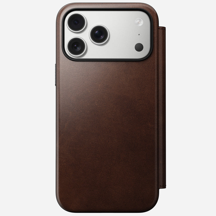 The Nomad Modern Leather Folio for iPhone 17 Pro Max in Rustic Brown Horween leather displays the phone's triple camera lenses from the back, set against a plain white background.