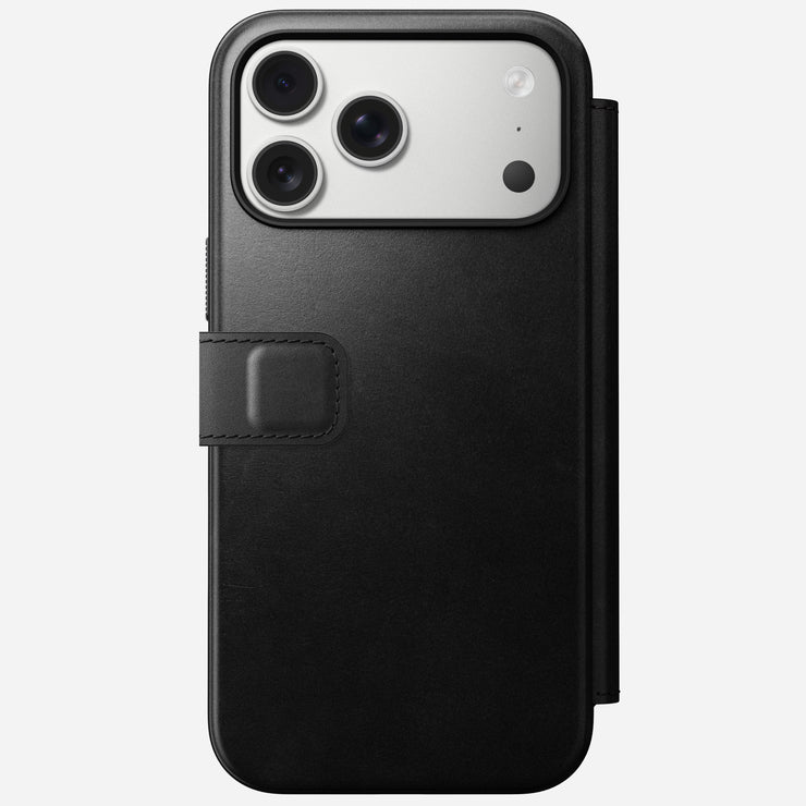 The Nomad Modern Leather Folio for iPhone 17 Pro Max in Black Horween leather is shown from the back with the case closed, triple-lens camera visible, magnetic clasp on the left side, and 8ft drop protection.