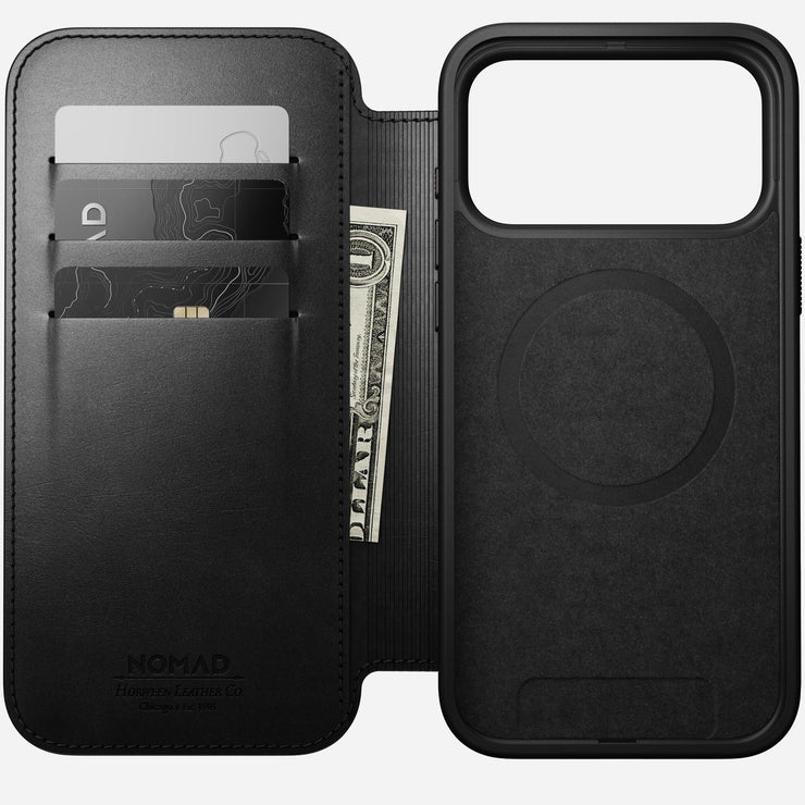The Nomad Modern Leather Folio for iPhone 17 Pro Max in black Horween leather features a wallet section that holds two cards and cash, with "Nomad" embossed for a premium finish. It sits beside a MagSafe-compatible cover.