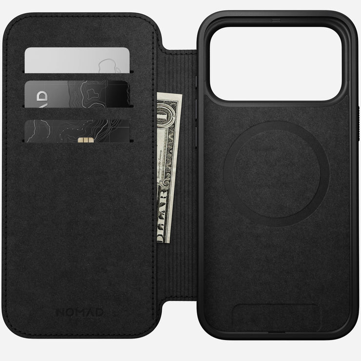 The Nomad Modern Leather Folio for iPhone 17 Pro Max in English Tan-C is shown open, revealing three card slots, each holding two cards and a folded dollar bill.