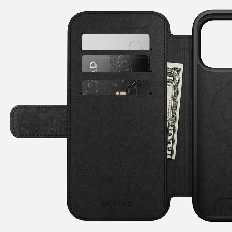 The Nomad Modern Leather Folio for iPhone 17 Pro Max in English Tan-C is open, displaying two card slots and a pocket for cash on the left flap, with the right side designed to securely hold your smartphone.