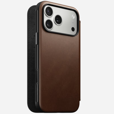 The Nomad Modern Leather Folio for iPhone 17 Pro Max in brown features full-grain leather, a fold-over cover, precise cutouts for the triple camera and side buttons, and a sleek MagSafe-compatible design for easy charging.