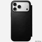 The Nomad Modern Leather Folio for iPhone 17 Pro Max in black, made from sustainably sourced leather, partially covers a triple-camera phone on a white background. "After 100 Days" appears in the bottom right corner.