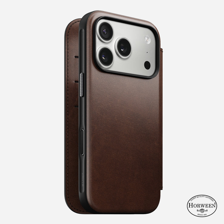 Nomad’s Modern Leather Folio for iPhone 17 Pro in Rustic Brown showcases Horween leather with stitching and logo, houses a modern smartphone with three rear cameras, and is MagSafe compatible—all displayed on a white background.