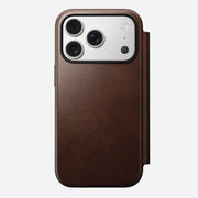 The Nomad Modern Leather Folio for iPhone 17 Pro in Rustic Brown Horween leather features a triple-camera cutout and MagSafe compatibility, shown from the back against a plain white background.