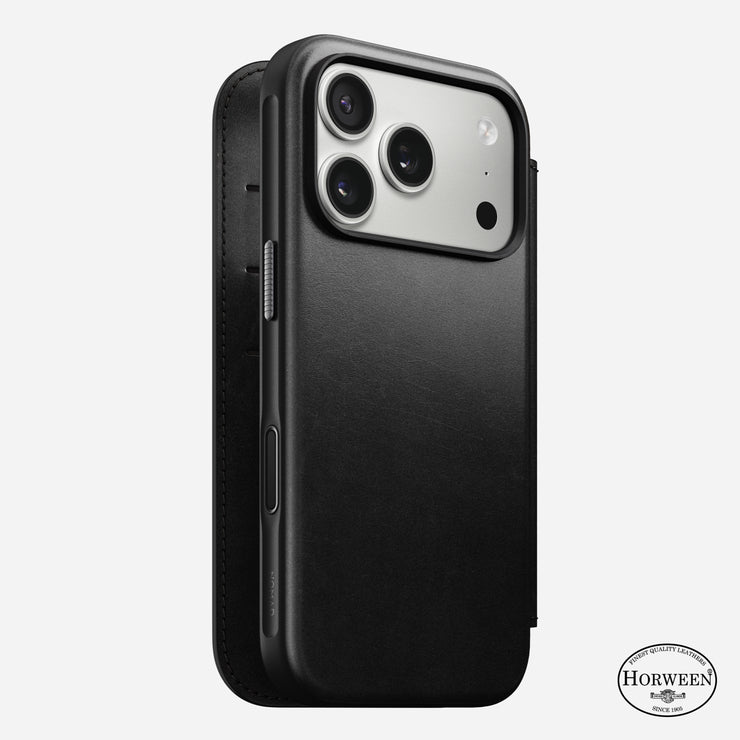 An iPhone 17 Pro is shown in a black Horween leather Nomad Modern Leather Folio case. MagSafe compatible, the case covers the back and sides, exposes three camera lenses, and displays the Horween logo at the bottom right.