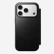 A Nomad Modern Leather Folio for iPhone 17 Pro in black Horween leather, shown from the back with a right-side cover; the phone has three camera lenses and a flash in the top left corner.