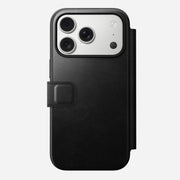 The Nomad Modern Leather Folio for iPhone 17 Pro in black Horween leather-like material features a magnetic clasp and fits a smartphone with three rear cameras and a flash, shown on a plain white background.