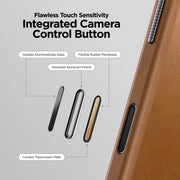 Diagram illustrating an integrated camera control button on the Nomad Traditional Leather Case - iPhone 17 Pro Max, with labeled parts: aluminosilicate glass, rubber membrane, aluminum frame, transmission plate, and full-grain leather surface.