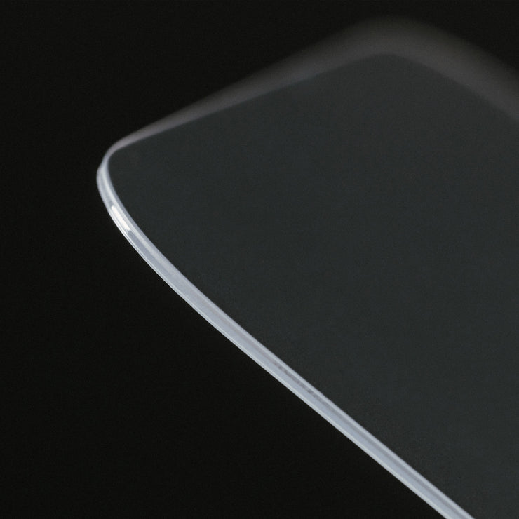 A close-up of the Nomad Screen Protector for iPhone 17 Pro, a thin, clear rectangular glass sheet with smooth, rounded edges and a glossy surface, displayed against a black background.
