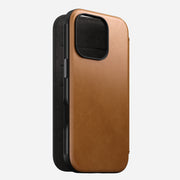 Angled front view of Modern Leather Folio for iPhone 16 Pro in English Tan-C by Nomad Leather. Shows full-grain leather with card slots, cash slot, and removable magnetic clasp. Provides 8ft drop protection and is compatible with MagSafe & wireless charging