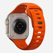 Back view of the Sport Band for Apple Watch in Ultra Orange, showing the interior ventilation channels and closure mechanism