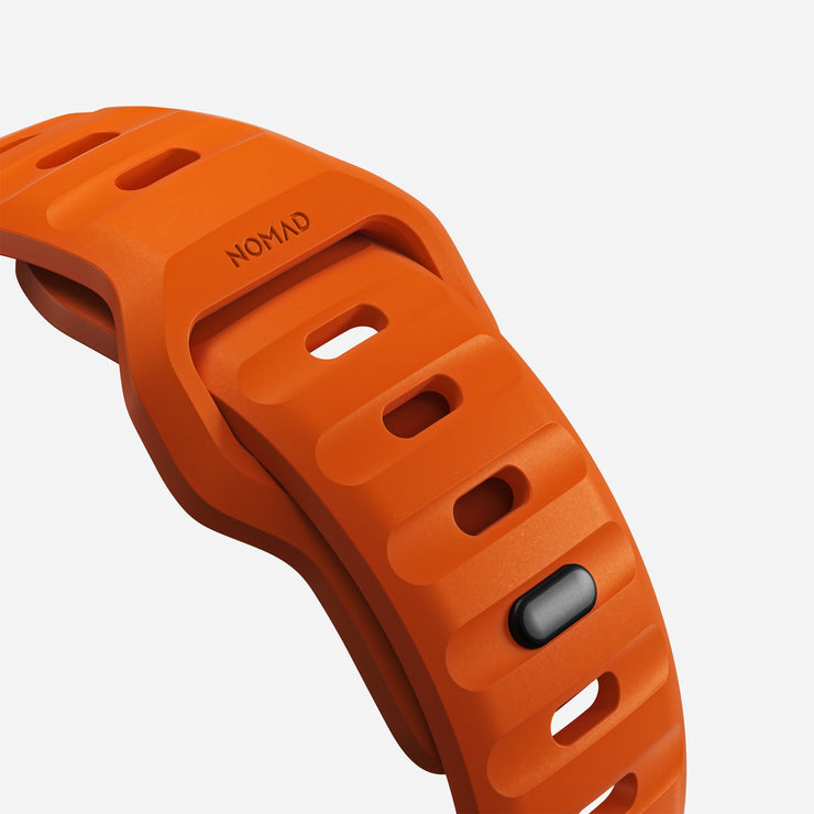 Close-up view of the Sport Band for Apple Watch in Ultra Orange, showcasing the texture and detail of the FKM fluoroelastomer material